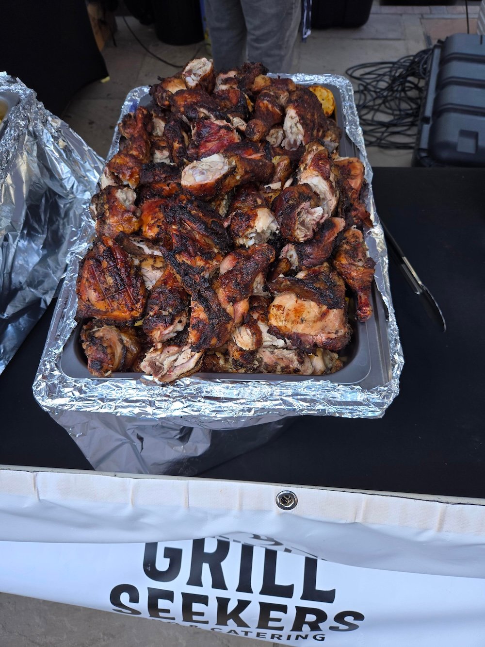 Tray of chopped grilled chicken above a Grill Seekers catering banner