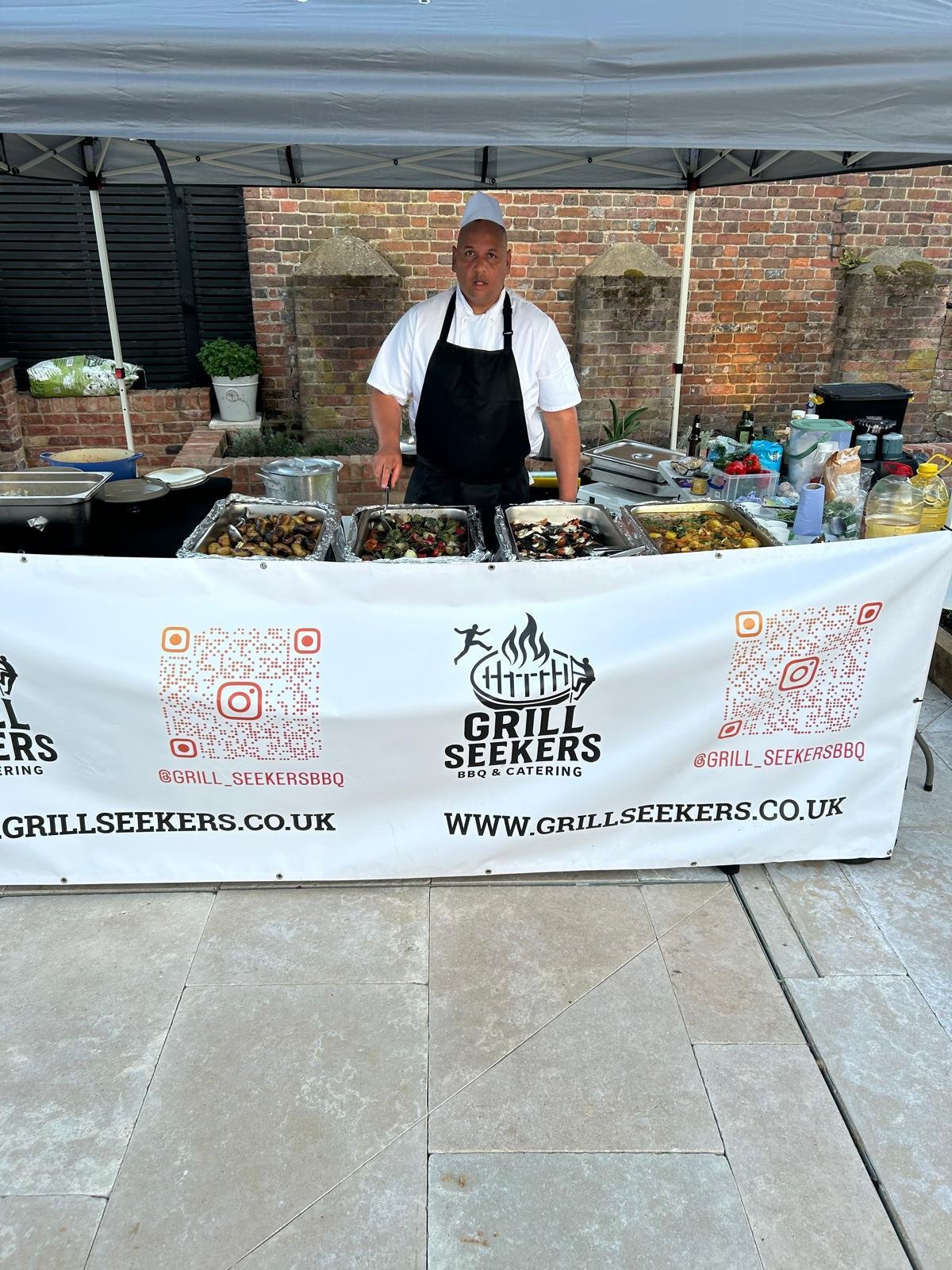 Grill Seekers chef serving from a branded outdoor food station