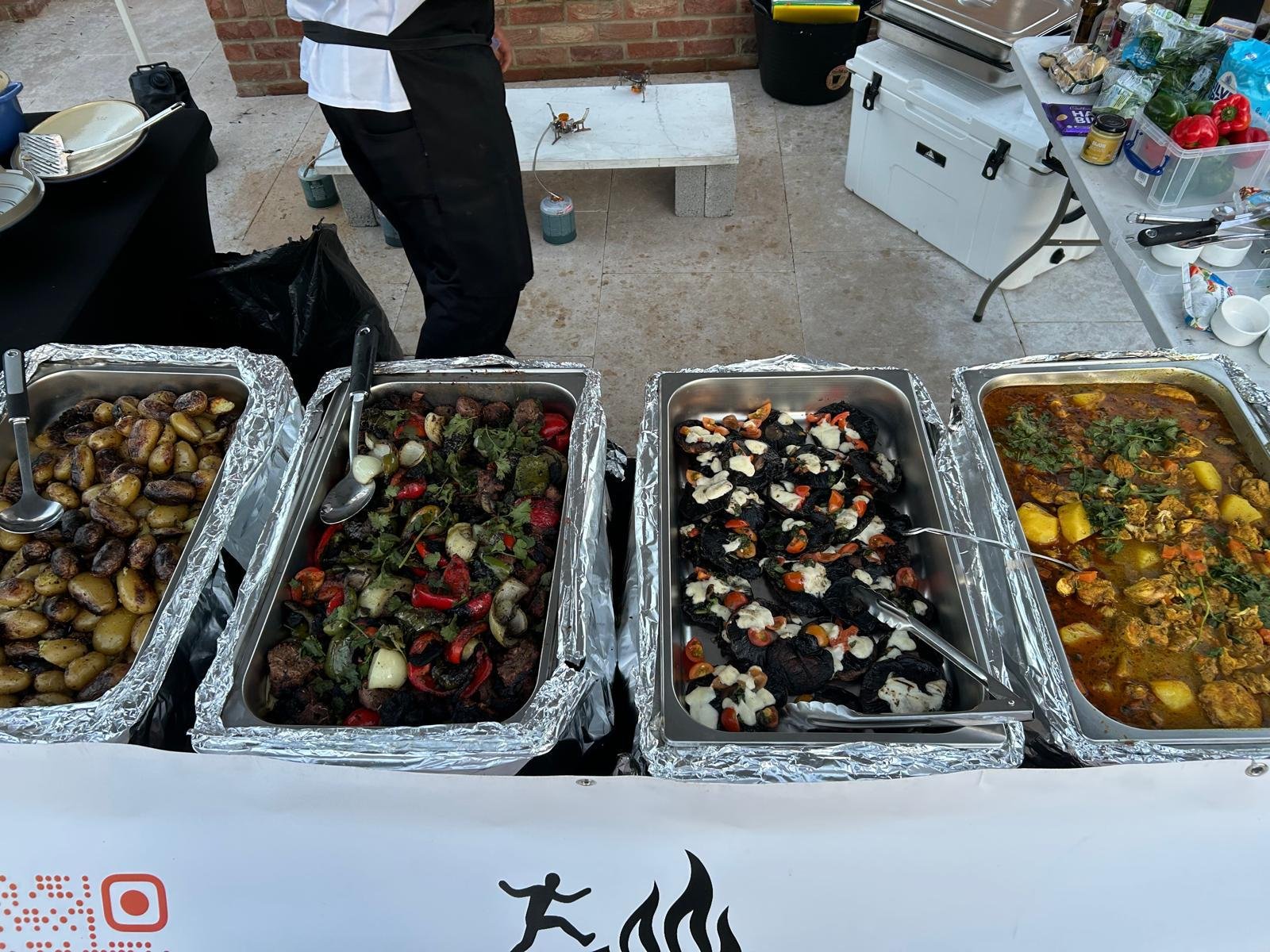 Buffet trays of roasted potatoes, grilled vegetables and hot dishes