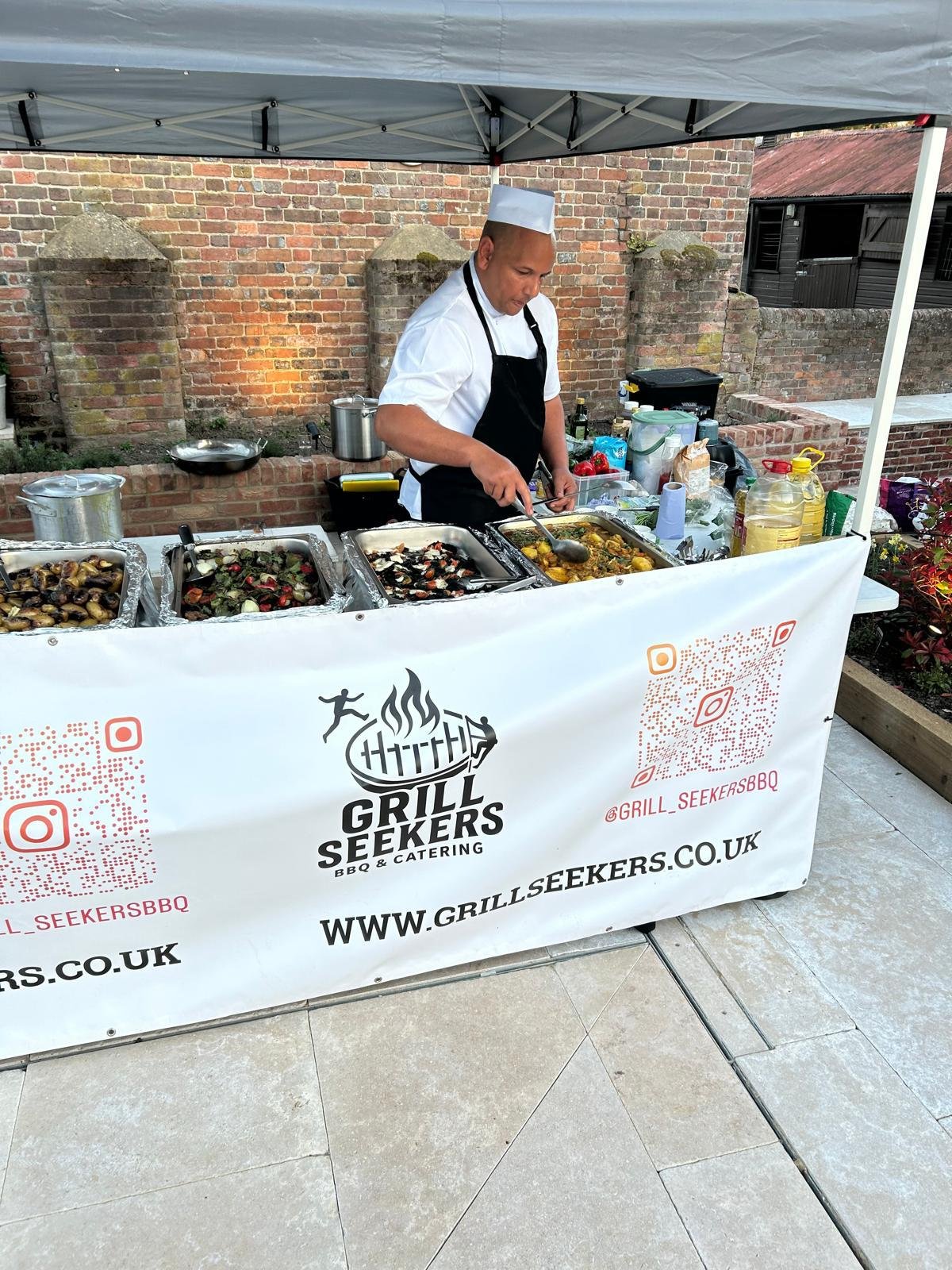 Grill Seekers chef serving food from an outdoor catering station