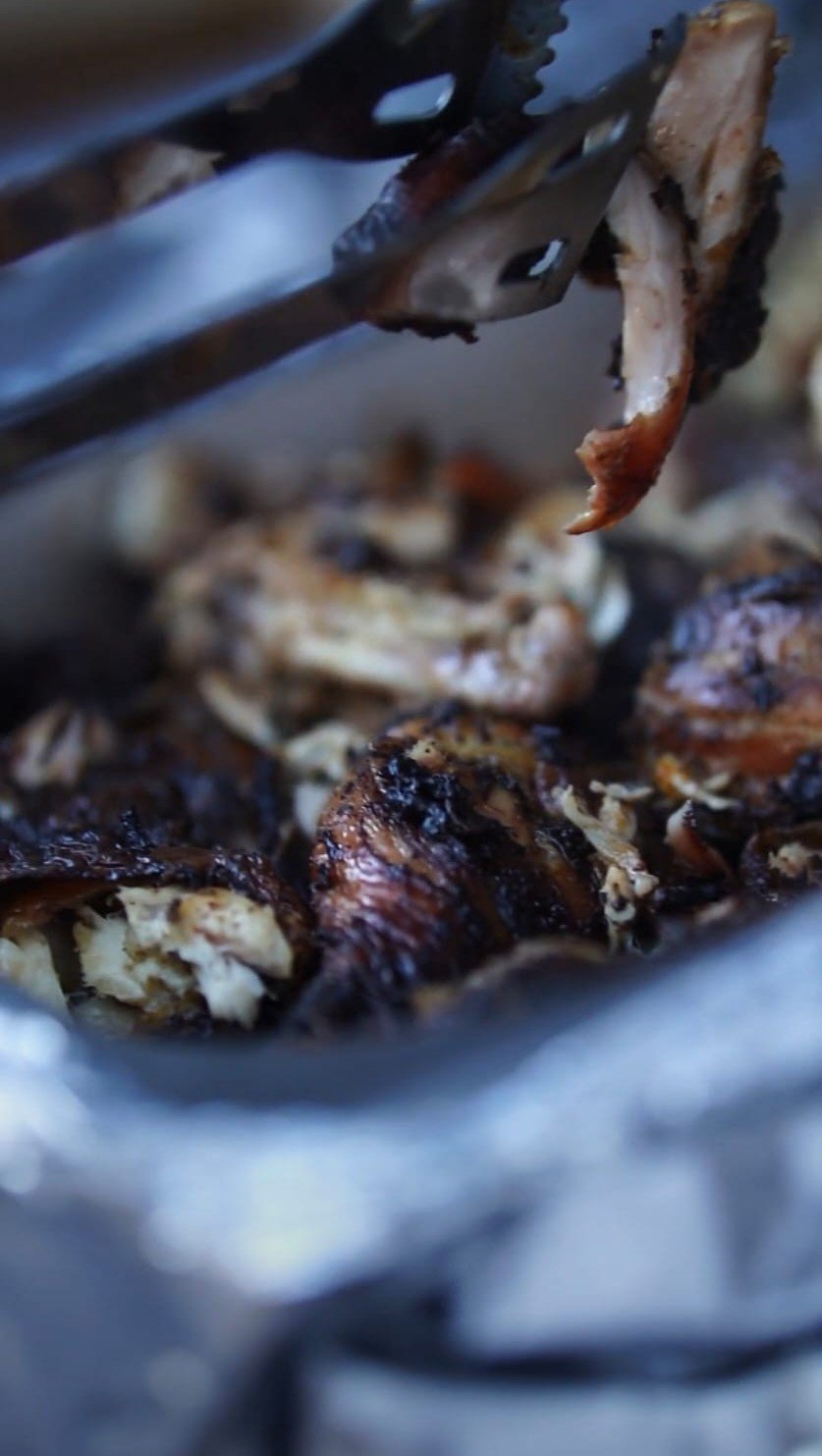 Freshly cooked barbecue chicken held over the grill